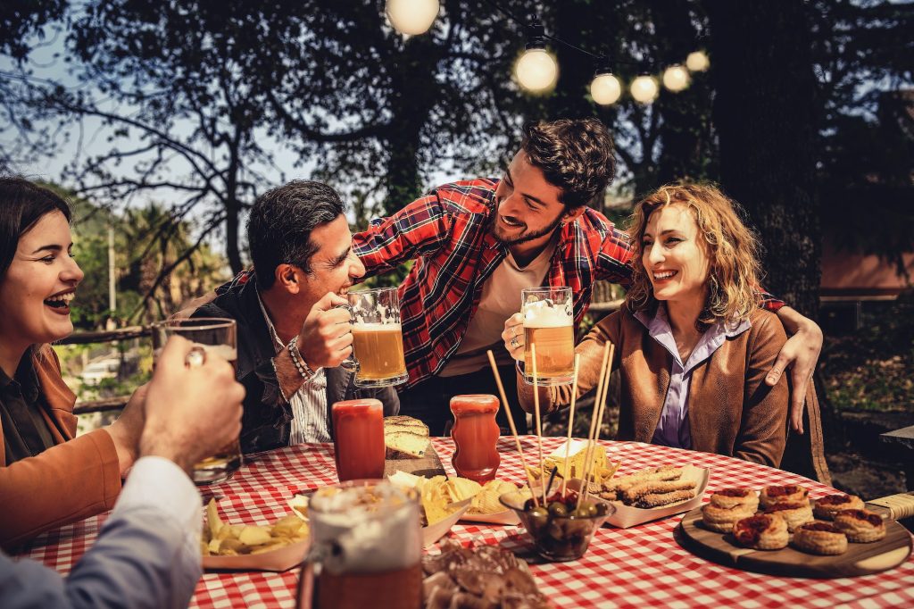 A group of close-knit friends have fun together eating and drinking