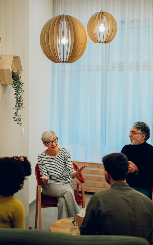 Senior woman psychologist on a group therapy session discussing mental health